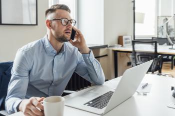 Man achter laptop aan het bellen