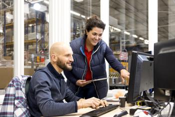 Man en vrouw in een magazijn achter een computer